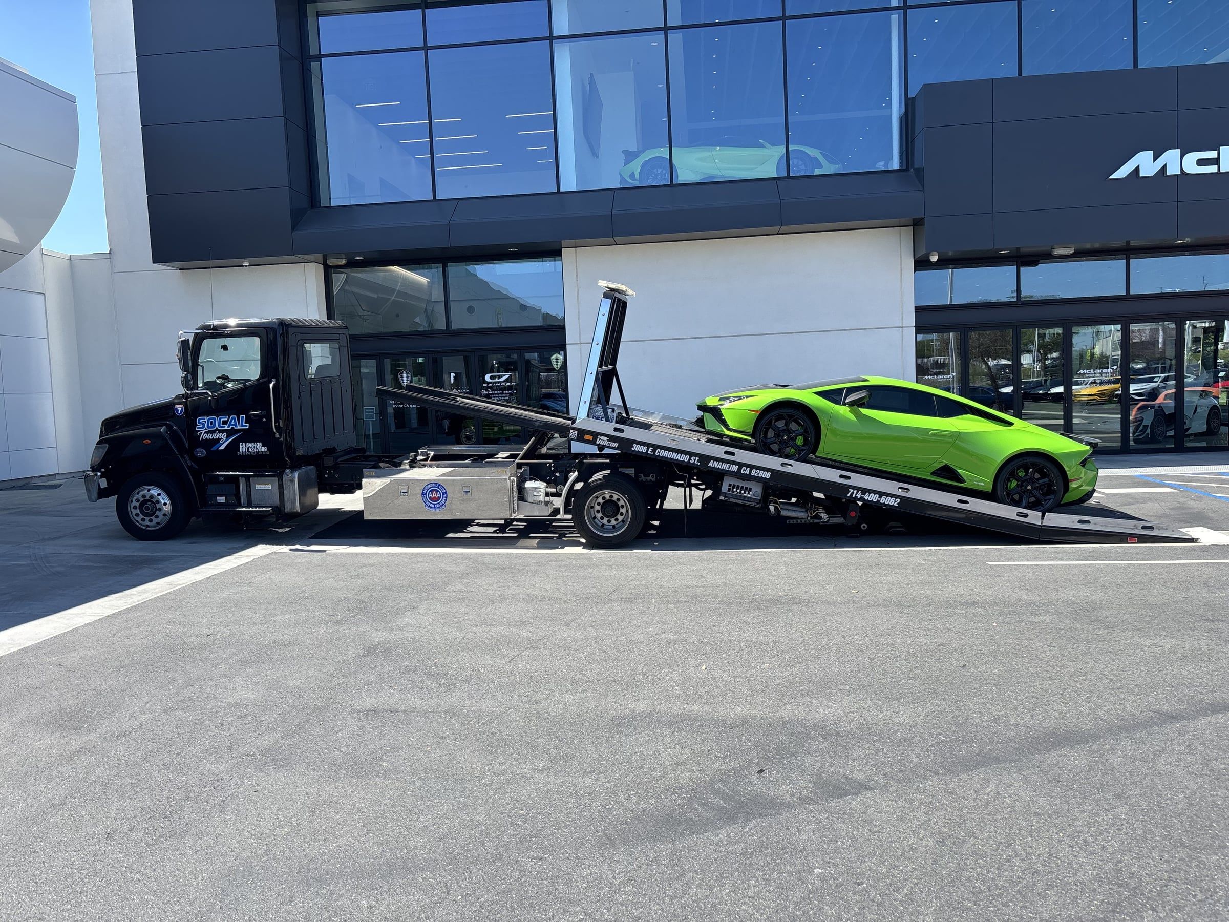 Lamborghini Huracan loading onto a SoCal Towing flatbed at a dealership